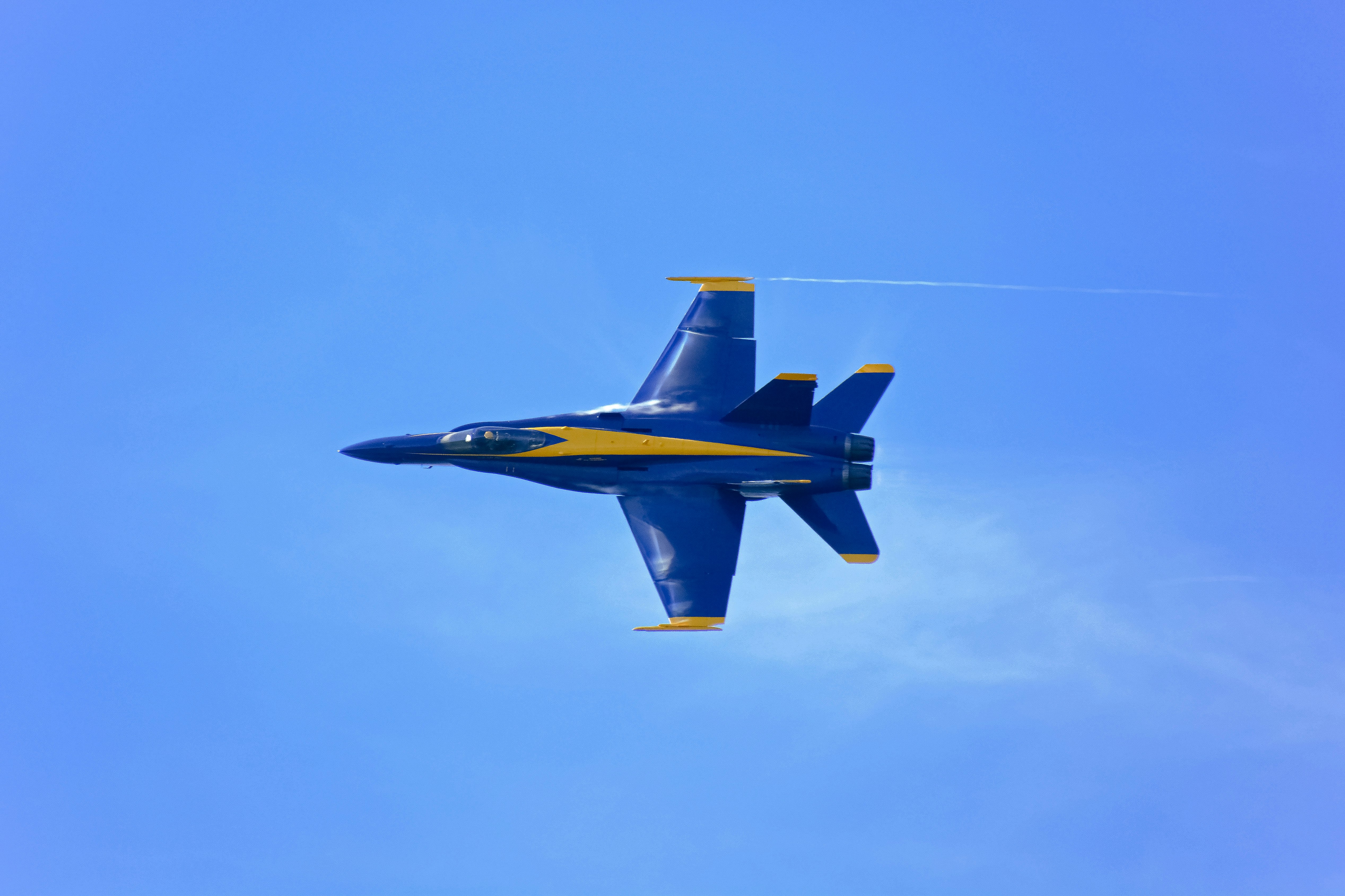 blue and yellow jet plane in mid air during daytime